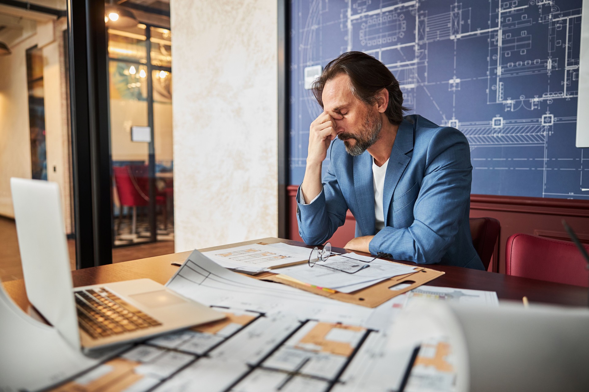 Distressed gentleman overcoming fatigue at his workplace